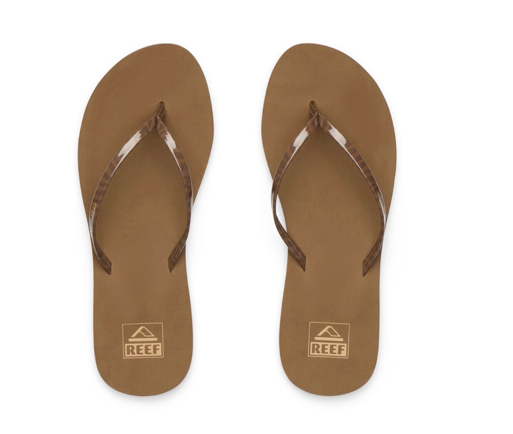 A pair of brown Reef brand flip-flops with patterned straps, shown from a top-down view on a white background.