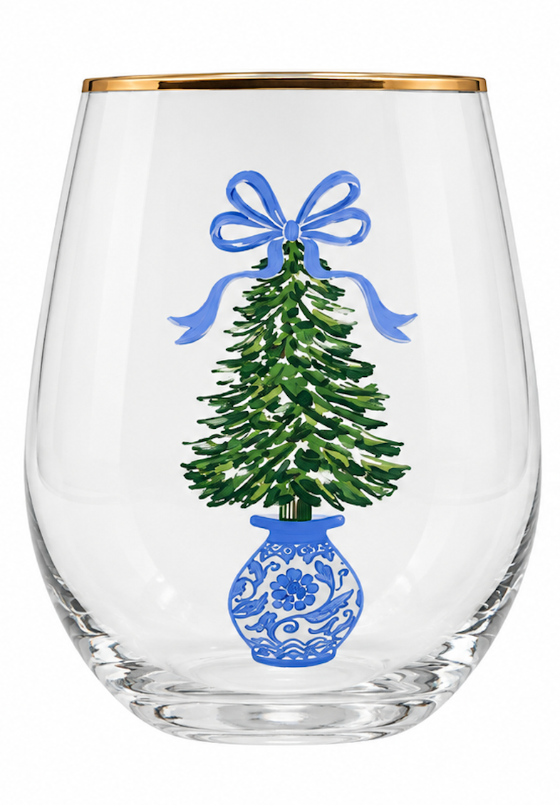 A clear stemless wine glass with a gold rim, featuring a printed illustration of a green Christmas tree in a blue patterned vase with a blue bow on the front.