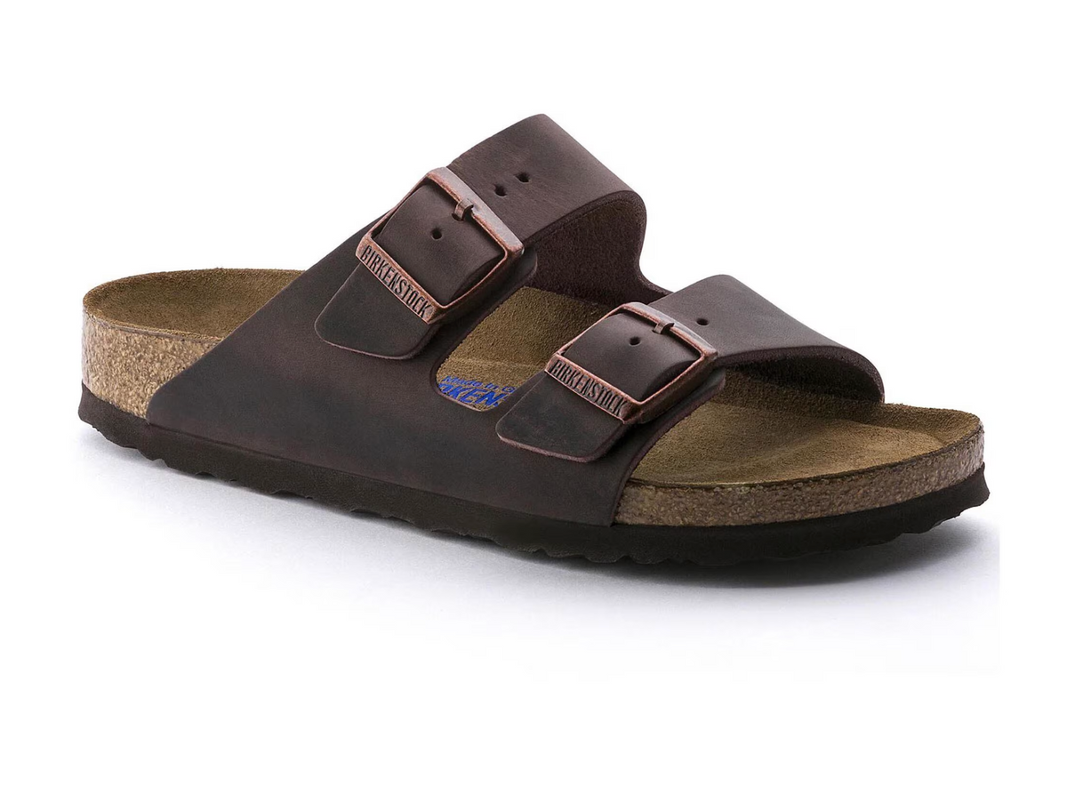 A pair of dark brown double-strap leather sandals with bronze-tone buckles and a contoured cork footbed, shown from a side angle on a white background.