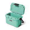 A mint green YETI cooler shown open, with the lid propped up and a black carry handle on the side, photographed on a clean white background.