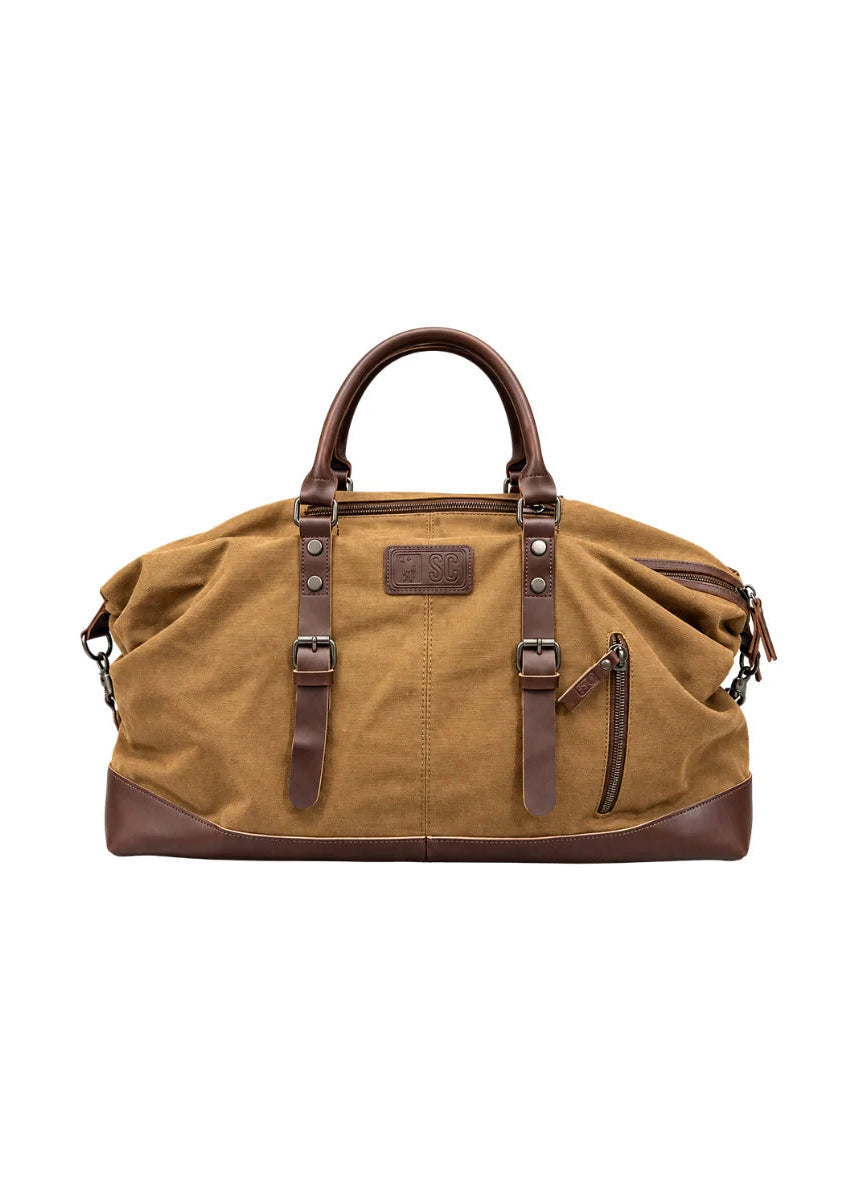 A tan canvas duffel bag with dark brown leather handles, trim, and buckle straps, shown against a plain white background.