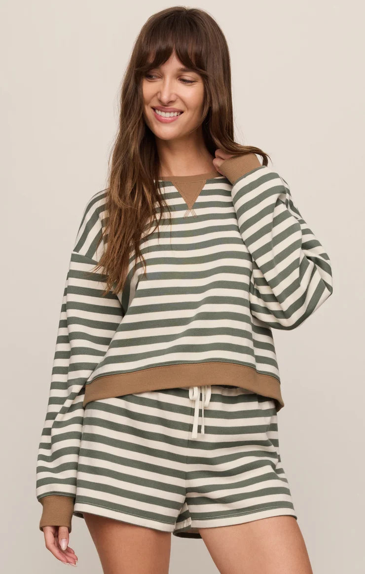 Woman wearing a green and white striped outfit on a beige background