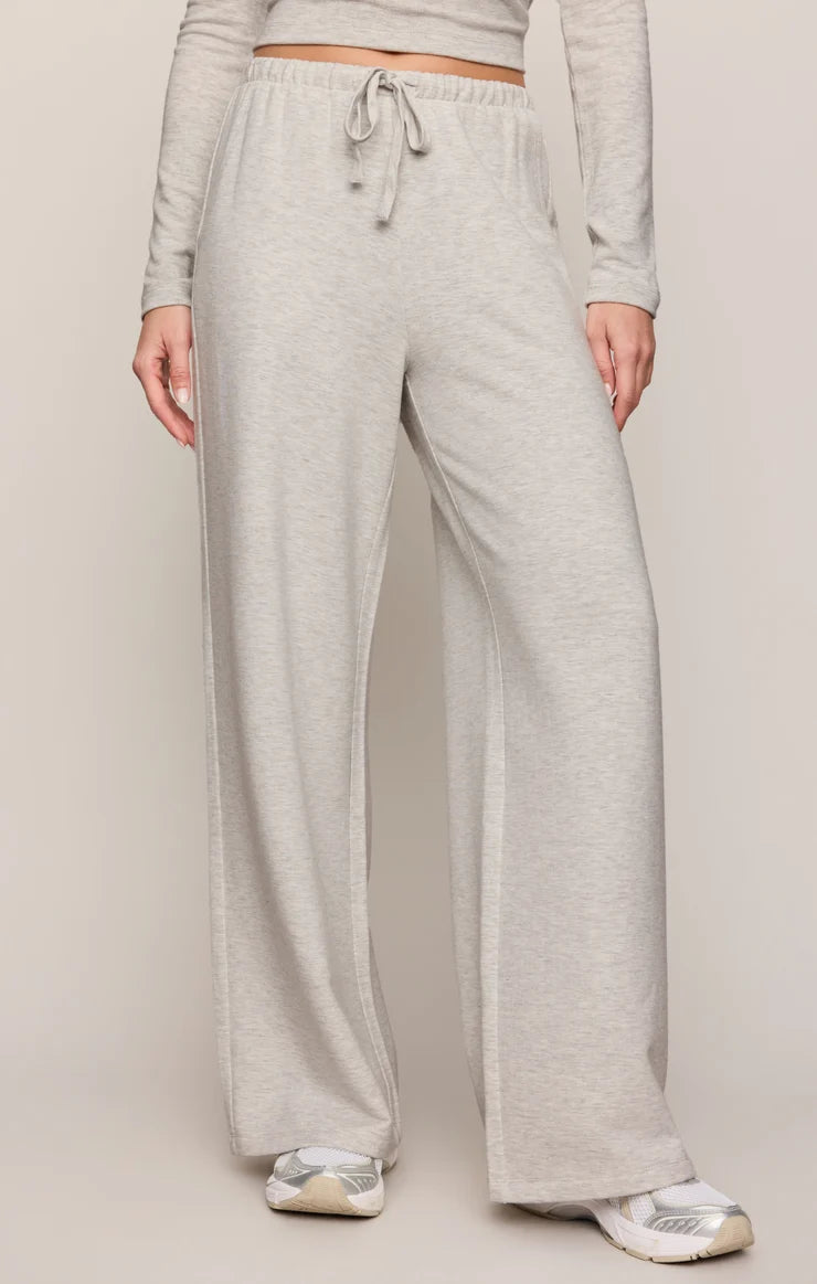 Person wearing gray sweatpants on a plain background