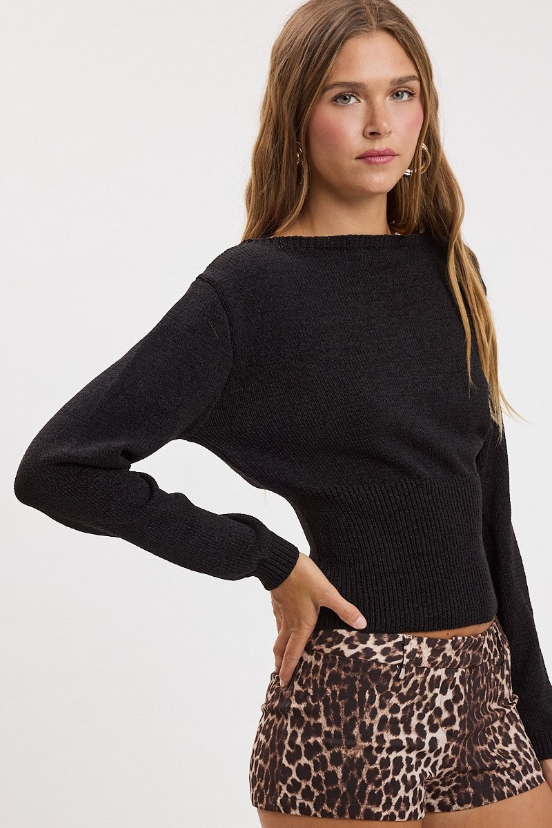 woman modeling boat neck sweater with fitted waist and boat neckline