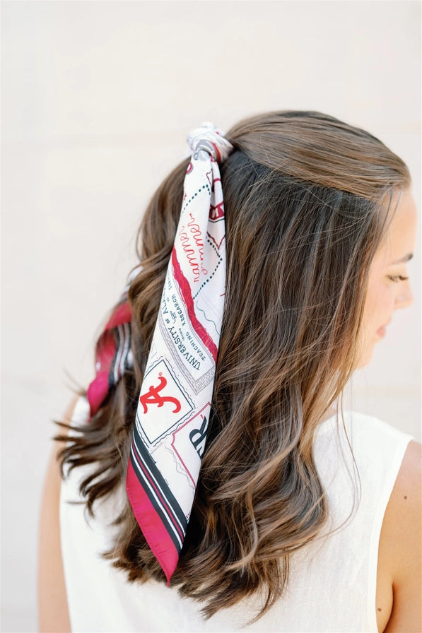 Woman wearing a patterned headscarf with a plain background