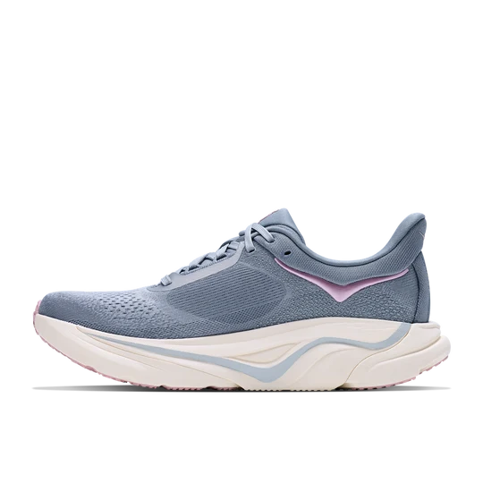 A light blue-gray knit athletic sneaker with a thick white and light blue wavy midsole and a subtle pink accent on the side, shown in profile against a white background.