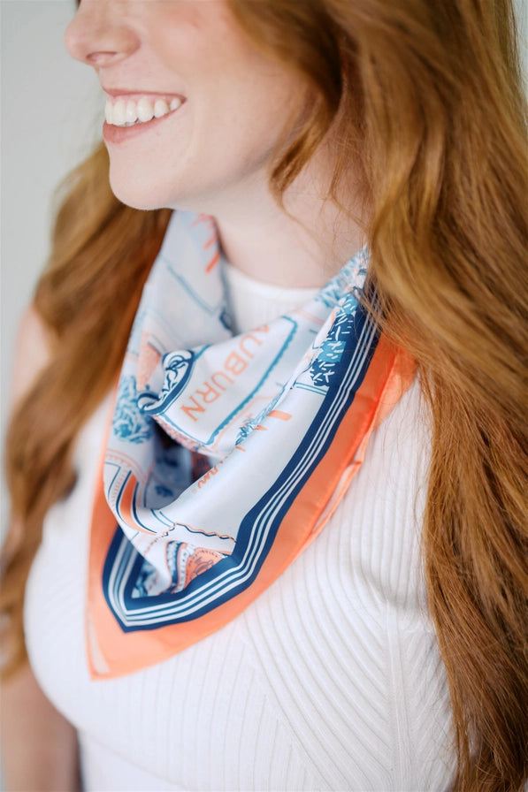 Woman wearing a colorful scarf with a design on a plain background