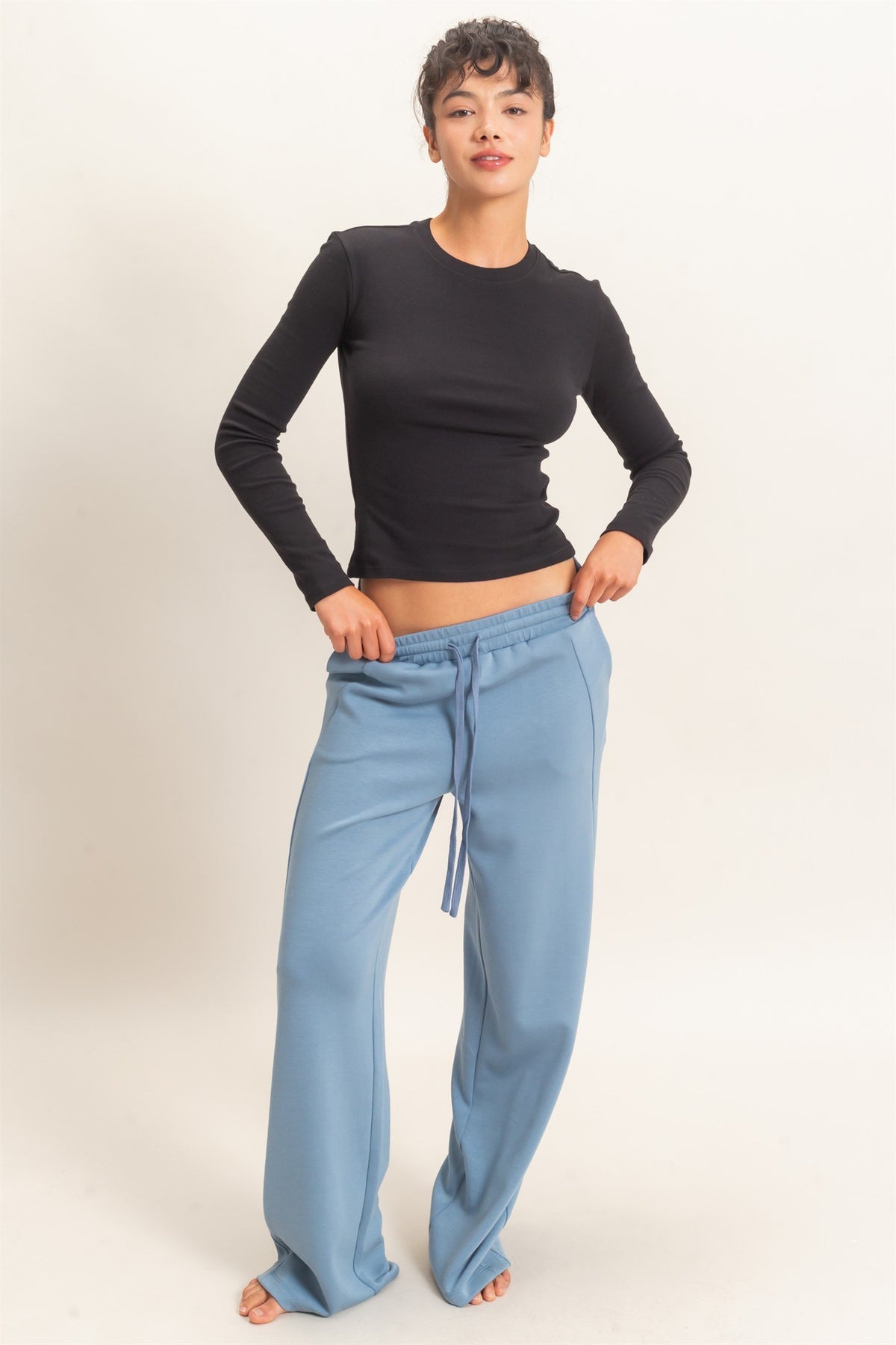 woman modeling blue sweatpants with fitted long sleeve black top 