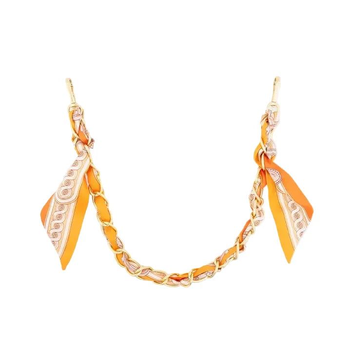 An orange and gold chain necklace with matching orange and white patterned silk scarf ends, displayed on a clean white background.