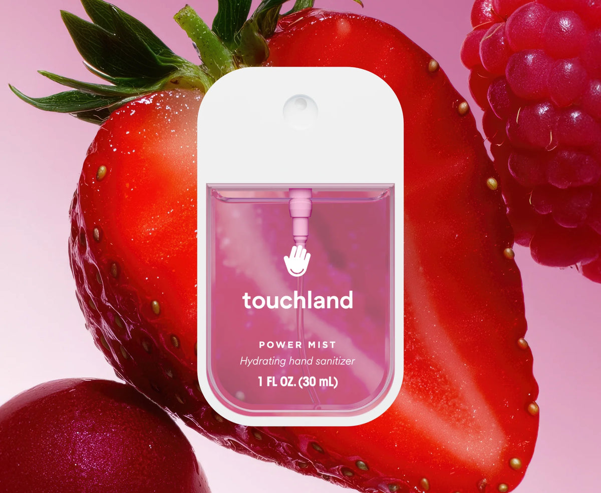 Touchland hand sanitizer packaging with a strawberry and raspberry on a pink background