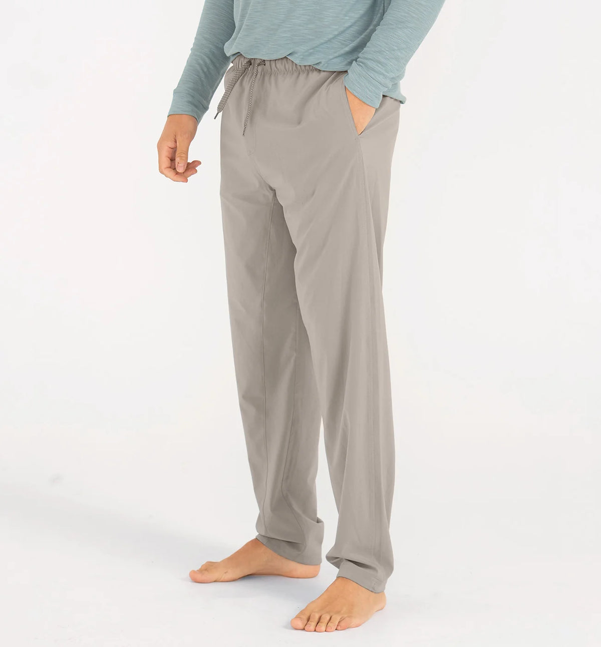 Person wearing gray pajama pants on a white background