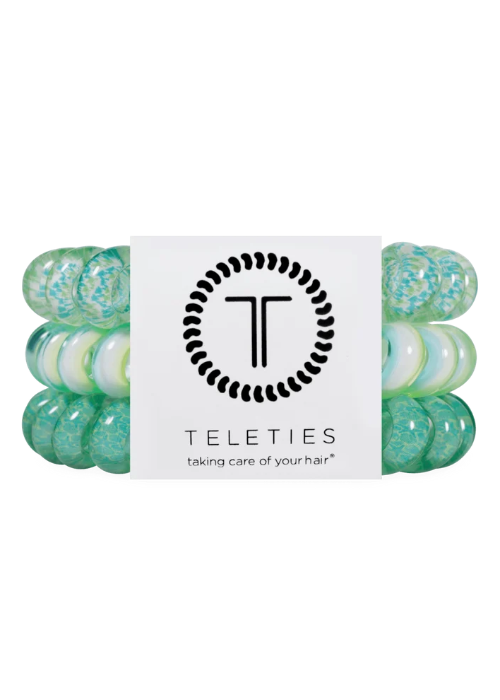 A set of four Teleties hair stretch bands in mint green and white marbled colors, wrapped with a white paper band featuring the black Teleties logo and brand name.