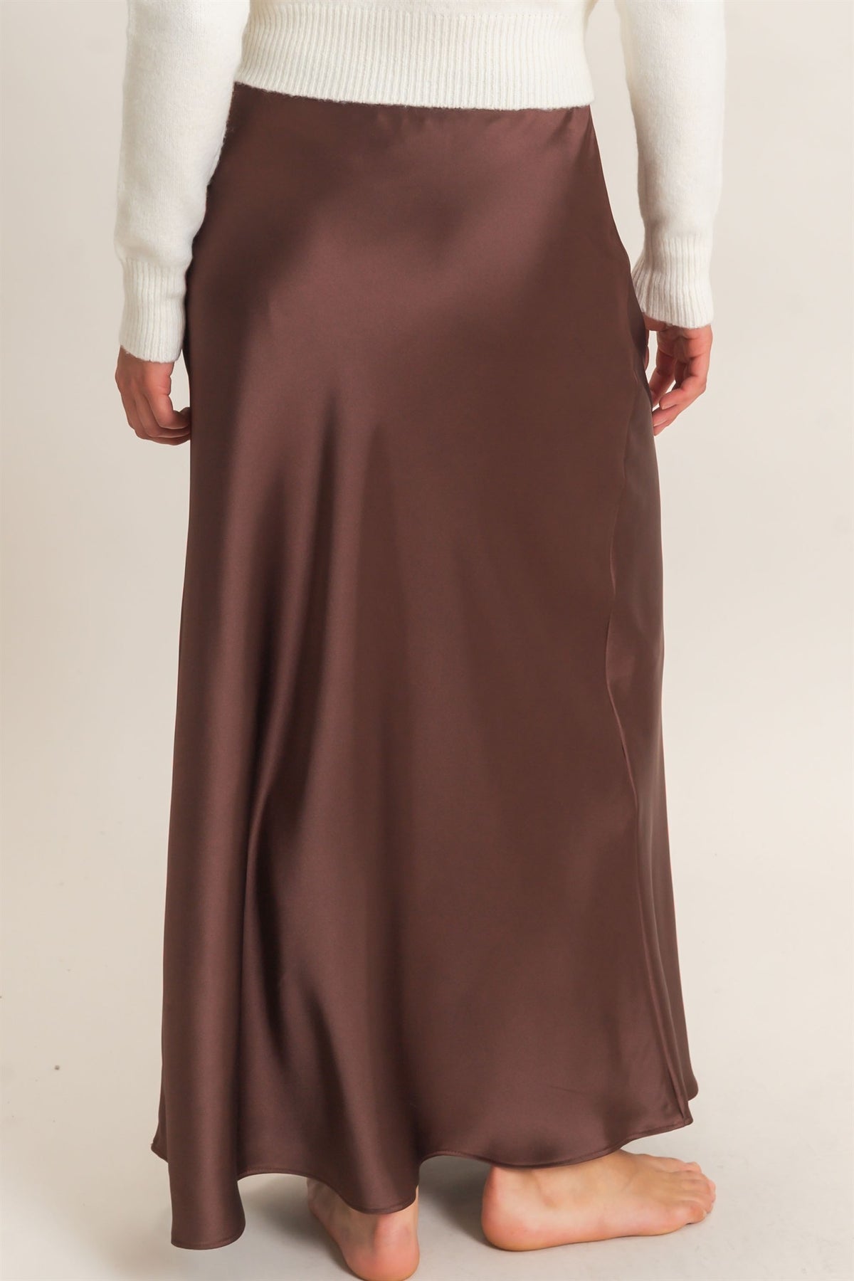 Brown satin skirt worn by a person on a plain background