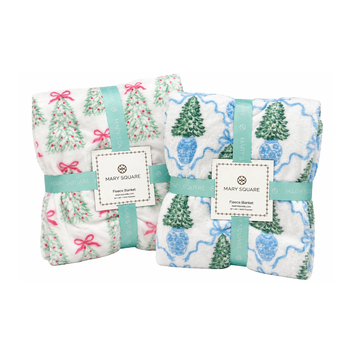 Two folded baby blankets from Mary Square, wrapped in mint green paper bands and white paper labels. One blanket has a white background with green pine trees and pink bows, and the other has a white background with blue pine trees and blue wavy lines.