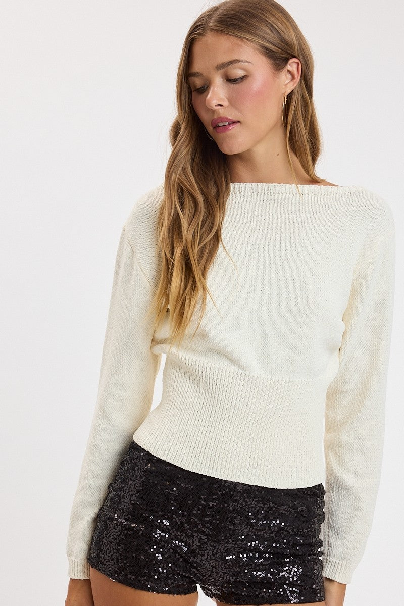 woman modeling boat neck sweater with fitted waist and boat neckline