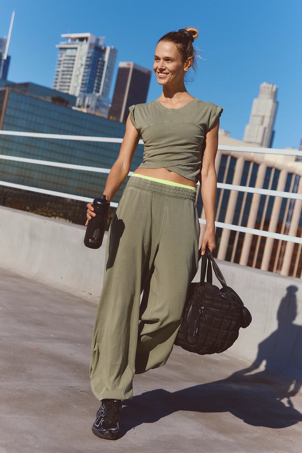 Woman in green outfit with a city skyline in the background