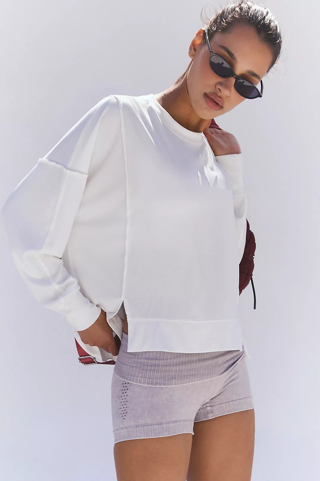 Woman wearing a long sleeve top that is white with shorts