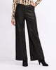 A model wearing black wide-leg faux leather pants, styled with a leopard-print long-sleeve top and black heeled boots, against a plain white studio background.