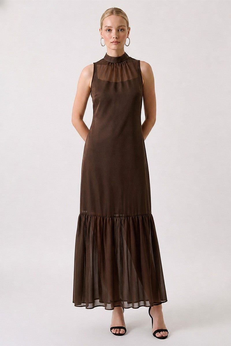 Woman wearing a brown dress with sheer neckline on a white background