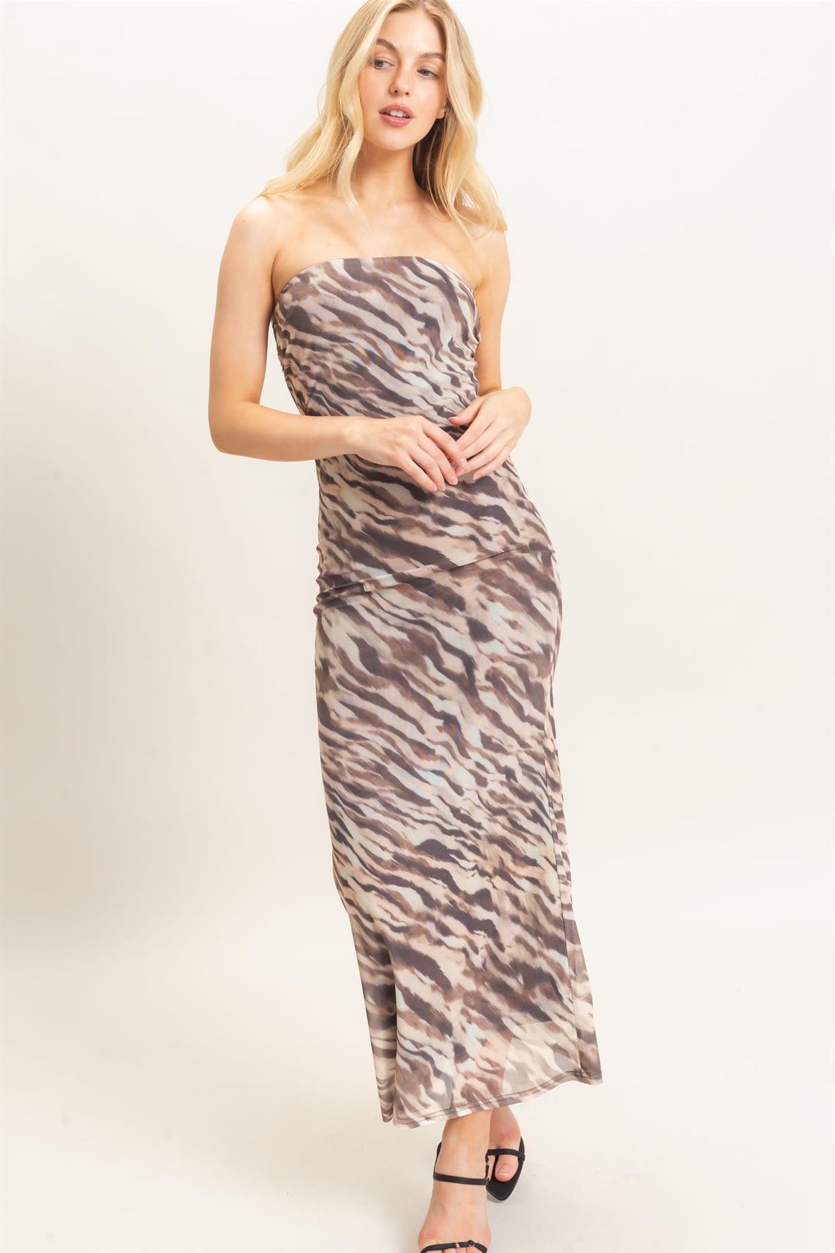 Woman wearing a strapless dress with a zebra print pattern on a white background