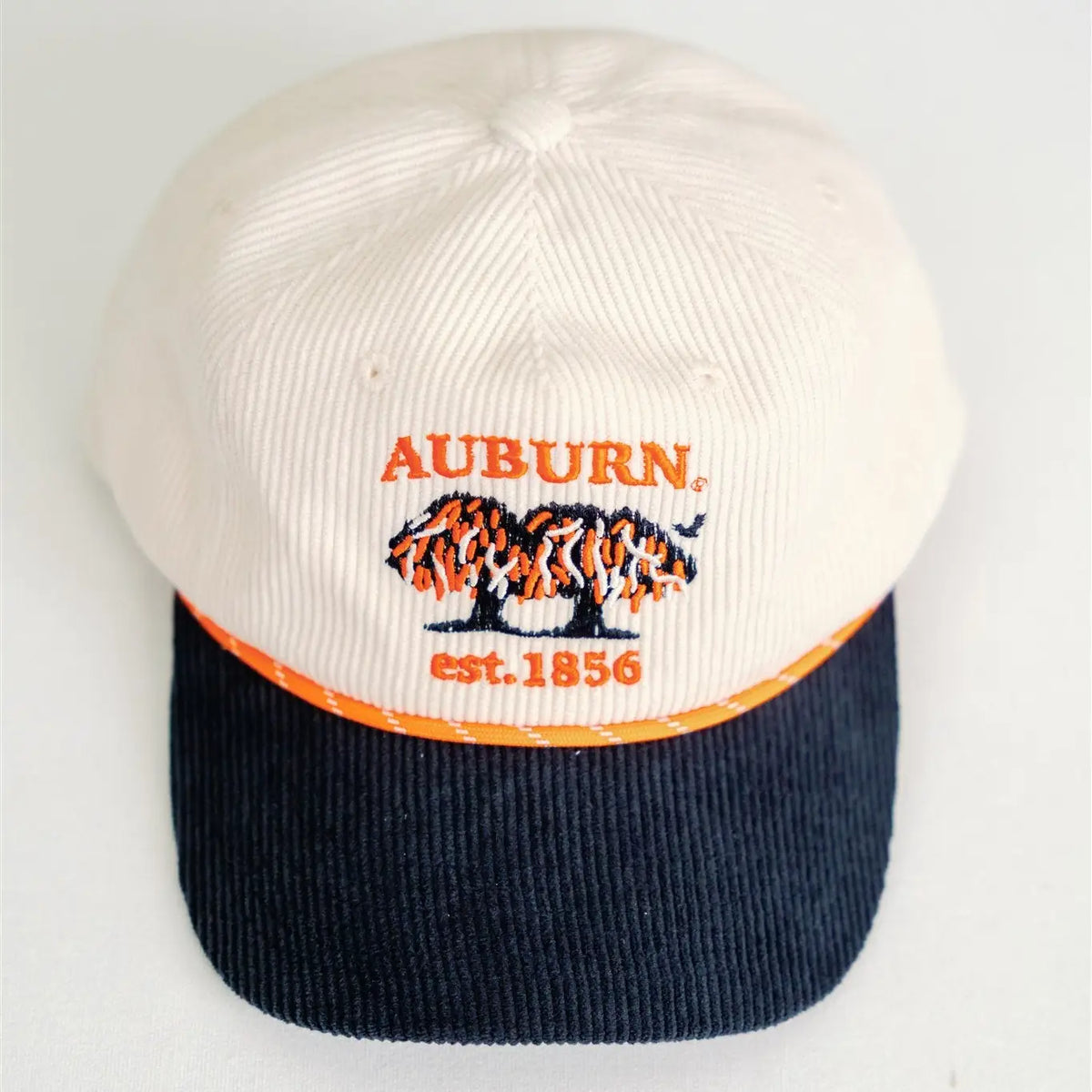 A vintage Auburn Tigers baseball cap featuring an off-white corduroy crown, a navy blue corduroy brim, and orange and black embroidered details on the front.