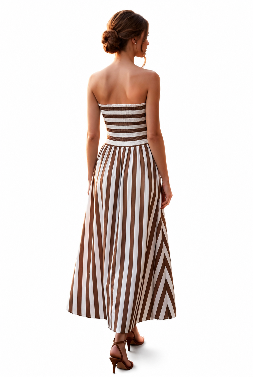 A woman viewed from behind wearing a strapless maxi dress with brown and white vertical stripes, paired with brown high-heeled sandals, against a plain white background.