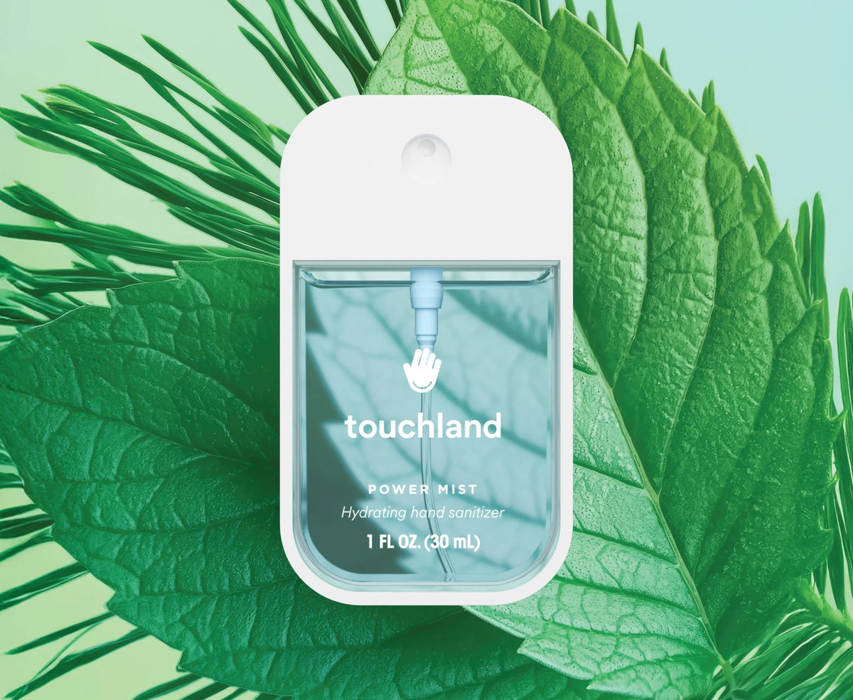 Touchland power mist packaging on a green leaf background
