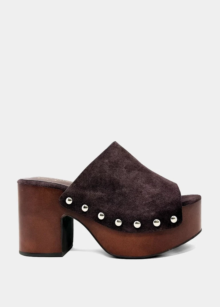 A single dark brown platform mule shoe with a suede-like upper, a chunky block heel, and silver metal studs along the side, shown against a light gray background.