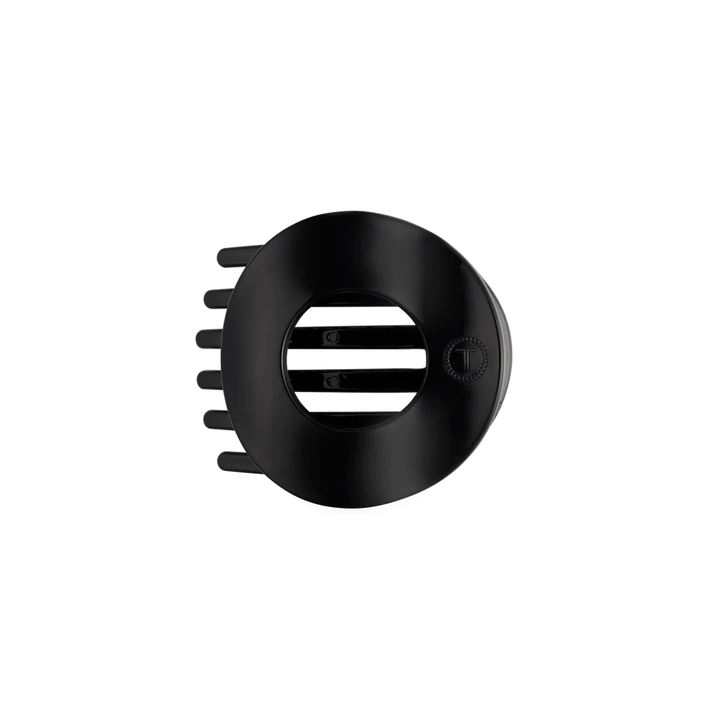 A matte black circular hair clipper guard attachment with a central slotted opening and side teeth, shown on a plain white background.