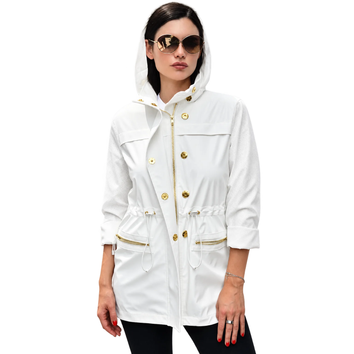 A woman wearing a white hooded jacket with gold-tone hardware, including a front zipper, decorative buttons, and drawstring details, paired with black pants against a plain white background.