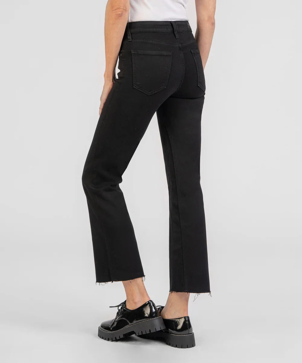 Person wearing black straight-leg jeans on a white background