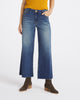 A model wearing a pair of wide-leg cropped blue denim jeans with a faded wash, styled with a yellow ribbed top and brown suede ankle boots against a plain white studio background.
