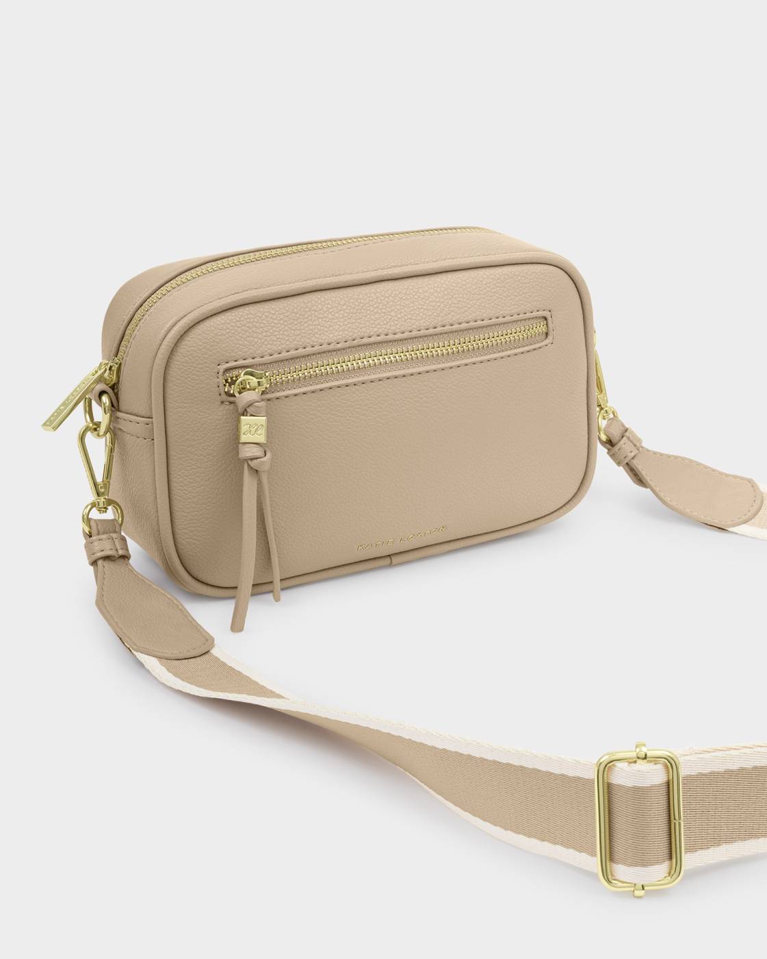 Beige crossbody bag with gold zippers on a white background