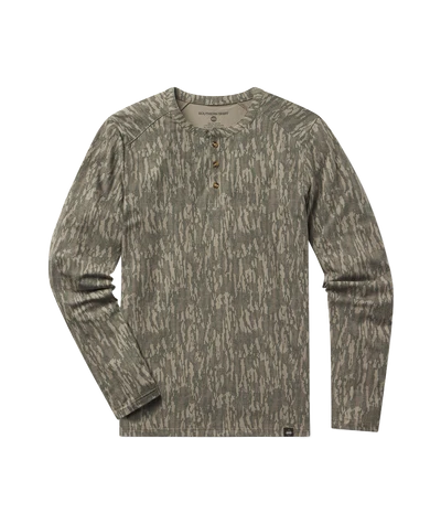 A long-sleeve henley shirt with an abstract bark-like camouflage pattern in olive green and beige, featuring a three-button placket on the chest.