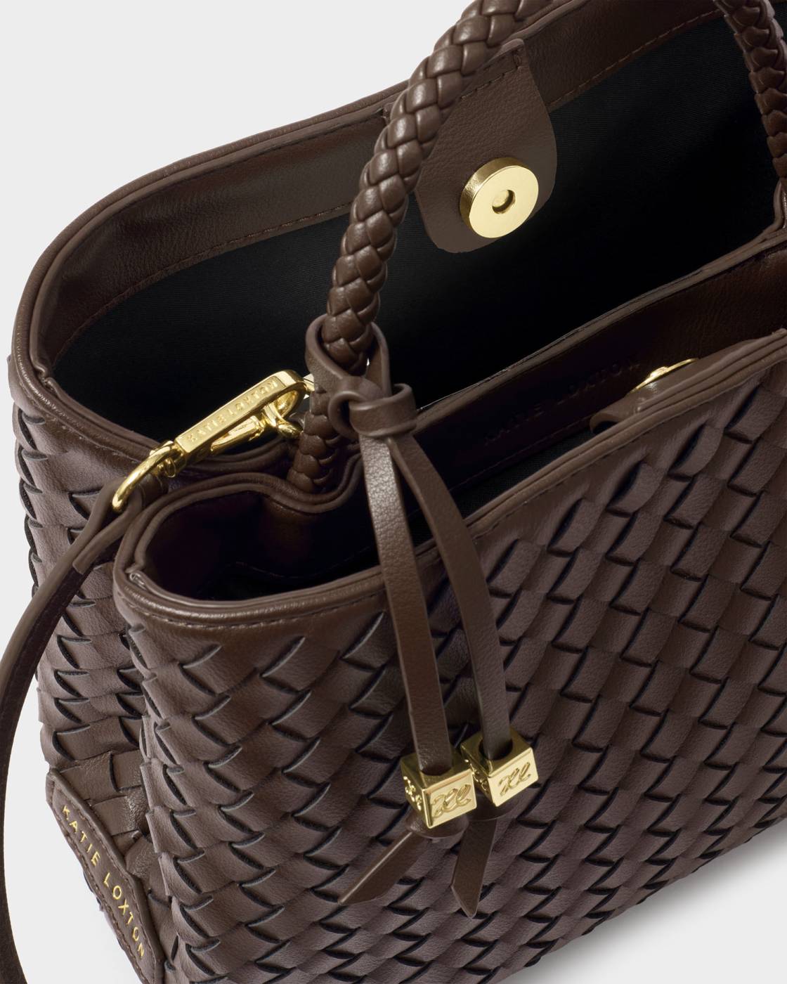 Brown woven handbag with gold accents on a light gray background