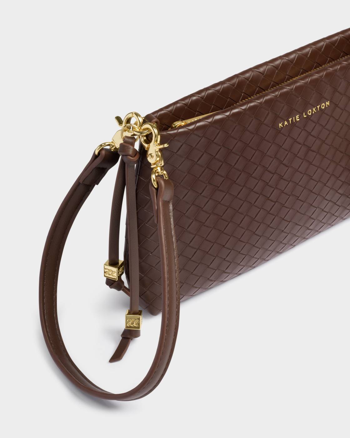 Brown textured handbag with gold accents on a light gray background