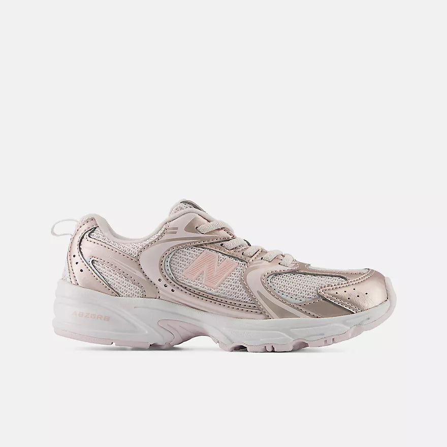 A New Balance athletic sneaker in a metallic rose gold and light pink colorway, shown from a side profile view against a light gray background.
