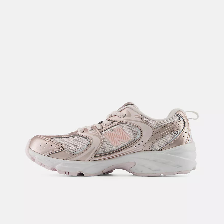 A New Balance low-top sneaker in metallic rose gold and silver mesh, featuring a chunky white midsole and a small white New Balance 'N' logo on the side.