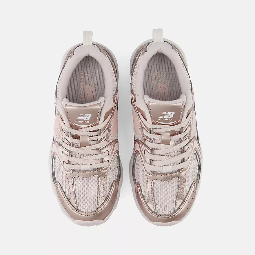 A pair of New Balance 9060 sneakers in a metallic rose gold colorway, shown from a top-down view on a light gray background.