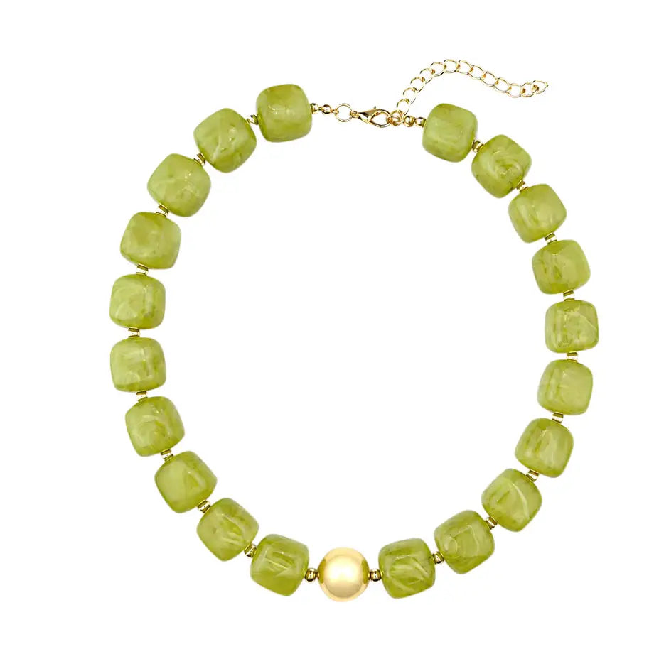A beaded necklace featuring light green faceted square beads and a single central cream-colored pearl, finished with a gold-tone chain and clasp.