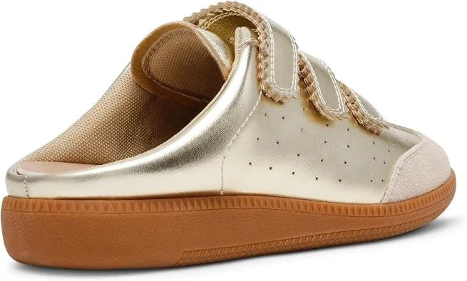 A metallic gold slip-on shoe with double hook-and-loop straps, a textured beige fabric lining, and a brown rubber sole, shown from a three-quarters angle on a white background.