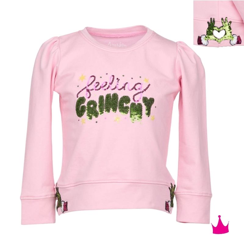 A pink long-sleeve sweatshirt for kids, featuring the phrase 'feeling GRINCHY' in glittery green and purple lettering on the front. The sweatshirt has puffed sleeves, ribbed cuffs, and a ribbed hem, with small green and pink character graphics near the lower hem.