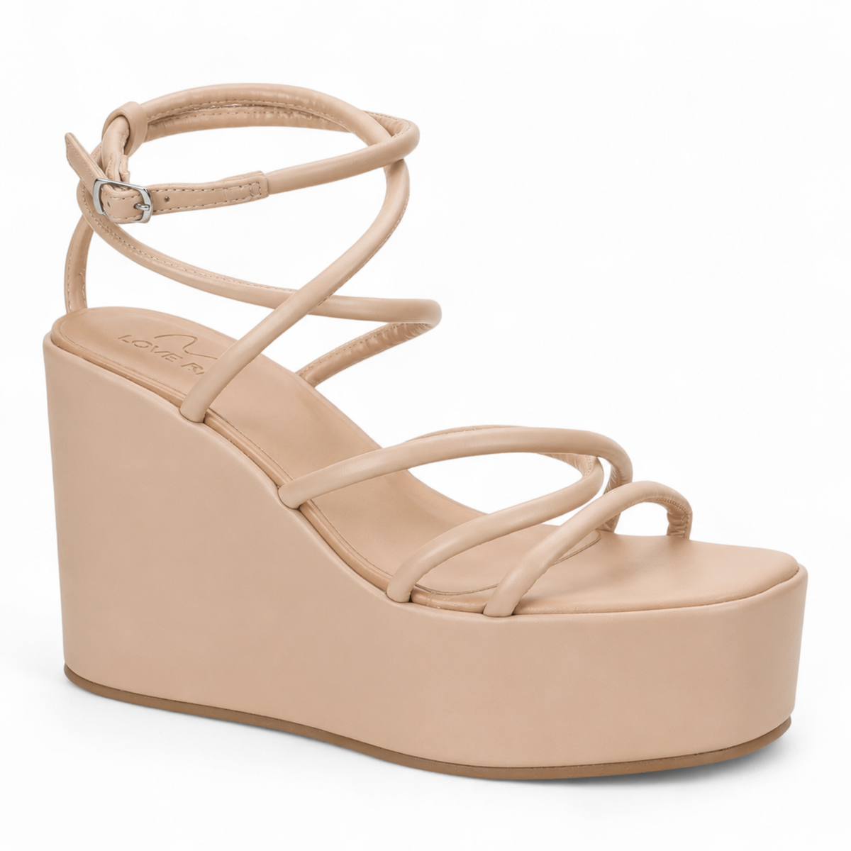 A single platform wedge sandal in a light beige/nude color, featuring criss-crossing straps and an ankle strap with a silver buckle, shown against a plain white background.