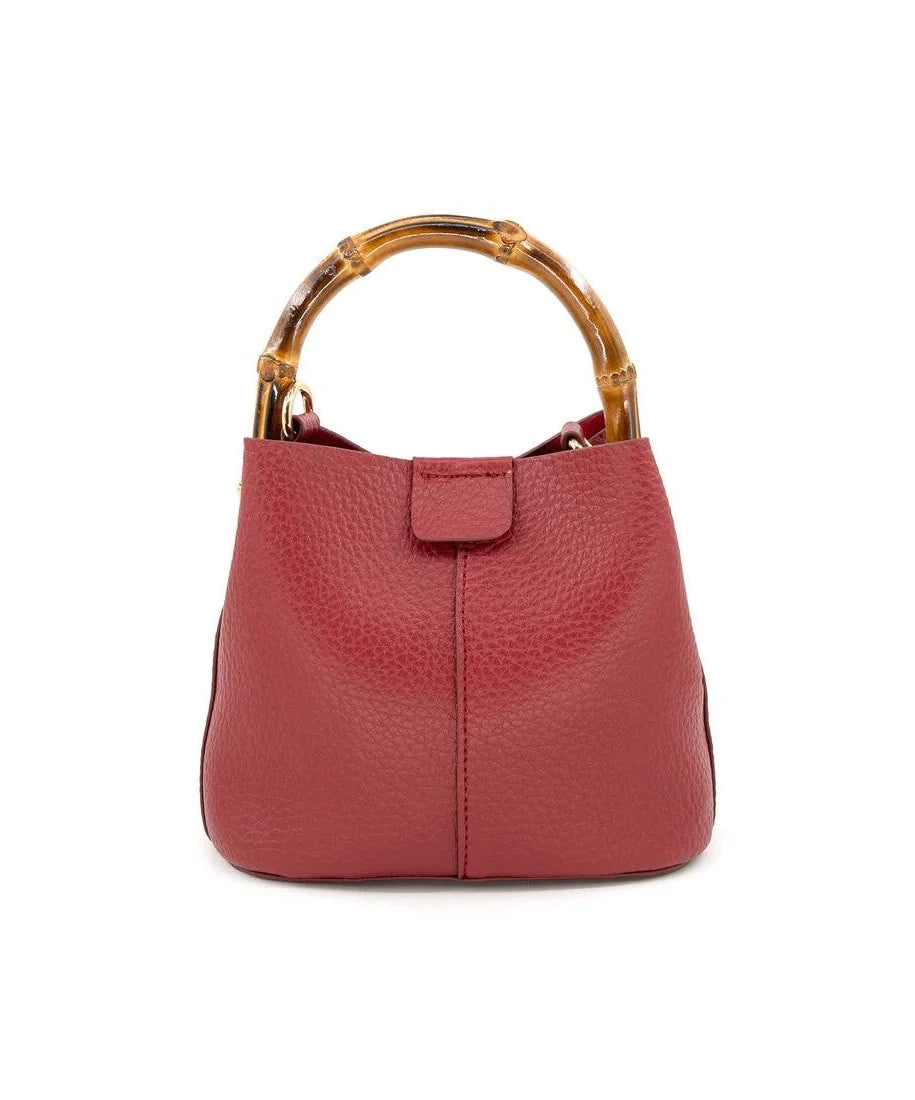 A red pebbled leather handbag with a curved bamboo handle, shown against a plain white background.