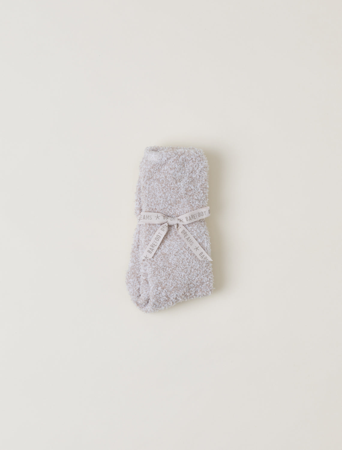 Gray textured socks with a white bow on a light beige background