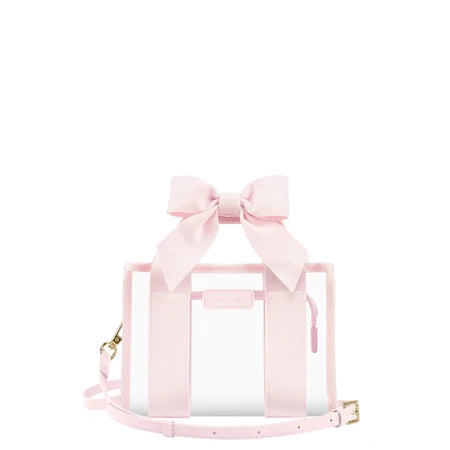 A light pink transparent tote bag with a large matching fabric bow on top, pink webbing handles, a thin shoulder strap, and small gold-tone hardware, shown on a plain white background.
