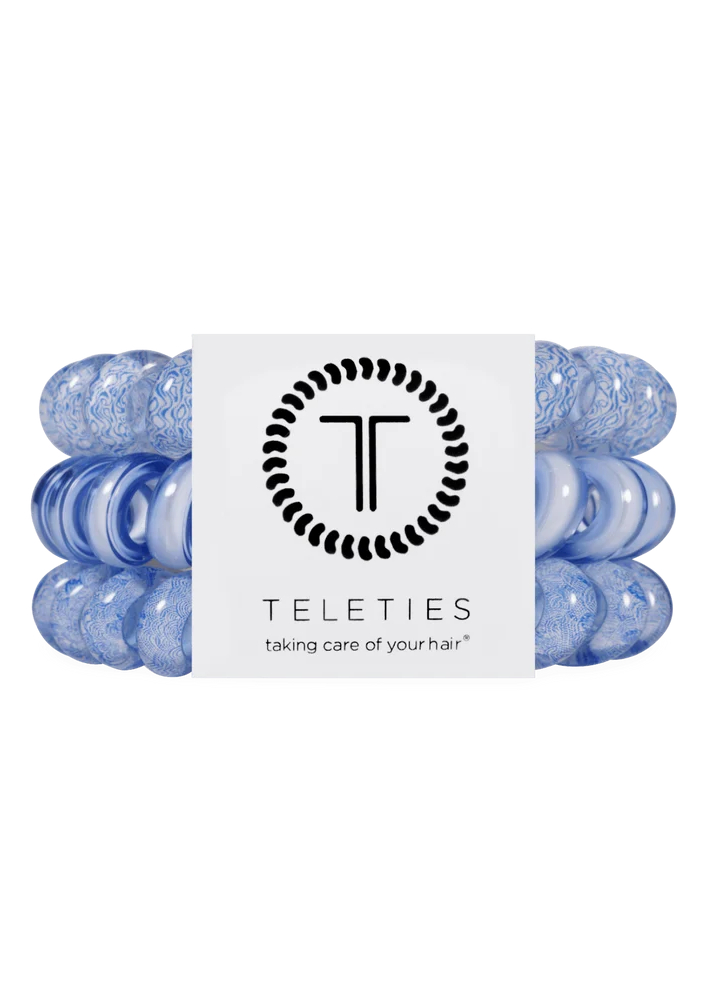 Set of blue hair ties with a white label featuring the 'Teleties' brand on a white background.