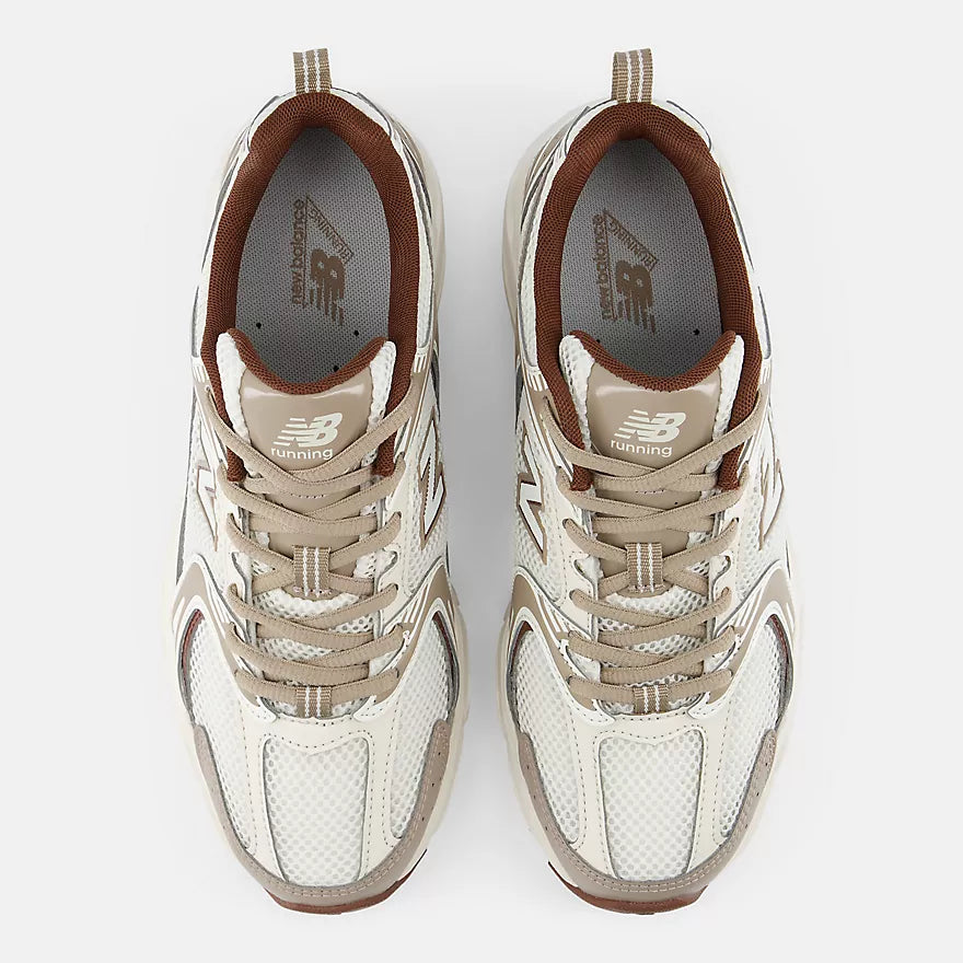 A pair of New Balance 9 Running sneakers shown from a top-down view on a light gray background. The shoes feature a cream and beige mesh upper with brown accents, including the collar lining, tongue details, and outsole edges.