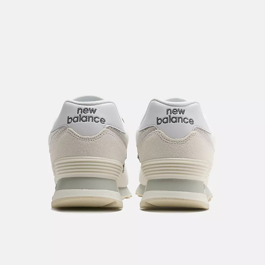 A pair of New Balance sneakers shown from the back, featuring a white and off-white suede and mesh upper with a light gray midsole and the 'new balance' logo in black on the heel tabs.